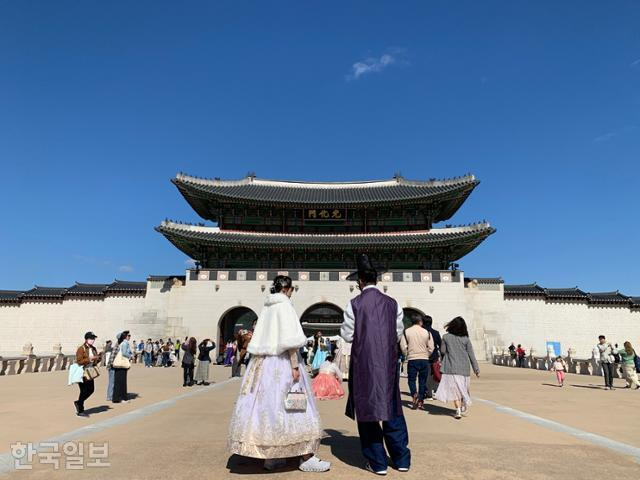 갑작스럽게 기온이 떨어진 20일 오후 서울 경복궁 앞에 한복과 함께 두꺼운 겨울 망토를 대여한 관람객이 서 있다. 강예진 기자