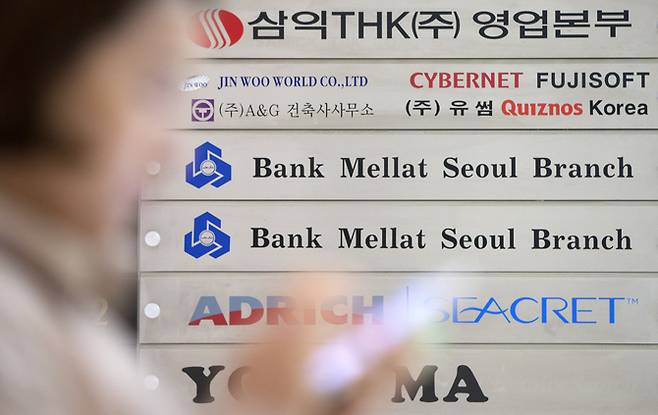 A passerby walks in front of a Bank Mellat Seoul Branch logo featured at the lender's office in southern Seoul. (Yonhap)