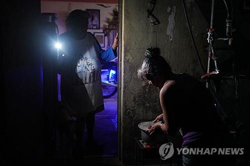 정전된 쿠바  쿠바에서 전국적인 정전 사태가 발생하면서 한 여성이 휴대전화로 불빛을 밝히고 있다. [AFP 연합뉴스. 재판매 및 DB 금지]