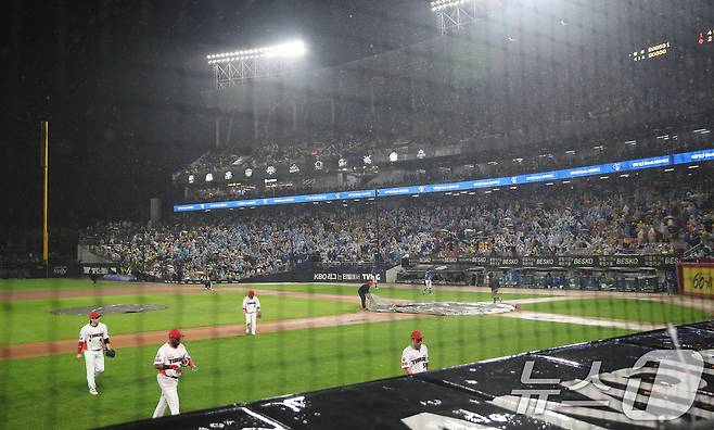 21일 오후 광주 기아챔피언스필드에서 열린 프로야구 '2024 신한 SOL 뱅크 KBO 포스트시즌' 한국시리즈 1차전 삼성 라이온즈와 KIA 타이거즈의 경기, 6회초 무사 1,2루 상황 우천으로 경기가 잠시 중단되자 선수들이 더그아웃으로 향하고 있다. 2024.10.21/뉴스1 ⓒ News1 임세영 기자