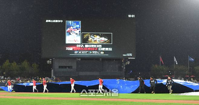 KIA와 삼성의 2024 KBO 한국시리즈 1차전이 예정된 광주-기아 챔피언스 필드에 비가 내리자 경기 전 방수포를 씌우고 있다. 광주 | 최승섭기자 thunder@sportsseoul.com