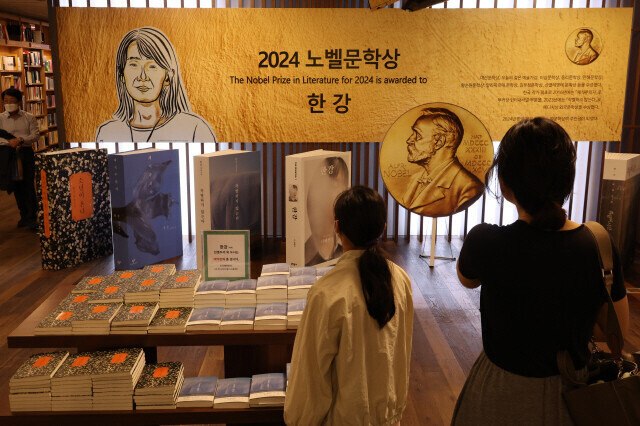 지난 14일 서울 종로구 교보문고 광화문점에 마련된 한강 작가 노벨 문학상 수상 기념 설치물을 시민들이 바라보고 있다. 김혜윤 기자 unique@hani.co.kr