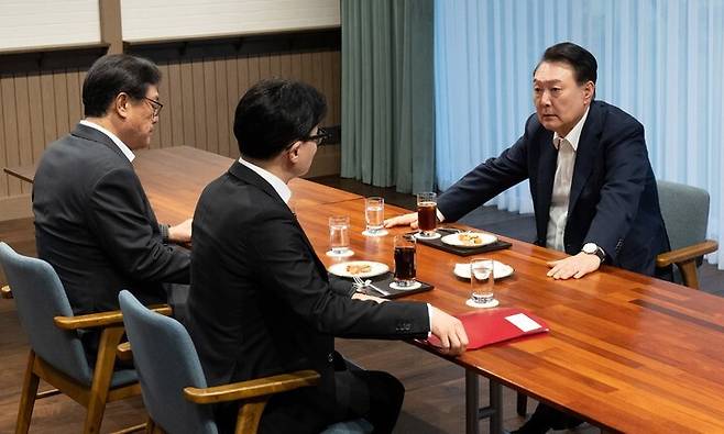 윤석열 대통령이 21일 서울 용산 대통령실 앞 파인그라스에서 국민의힘 한동훈 대표를 만나 대화하고 있다. 이 자리에는 정진석 대통령 비서실장이 배석했다. 대통령실 제공