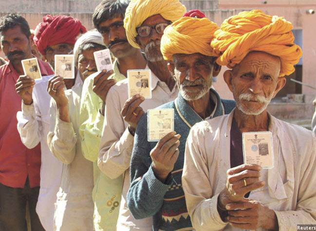 인도 라자스탄 주 아즈메르의 한 마을에서 민간 은행이 주최한 은행 계좌 개설 캠프에 참여한 마을 주민들이 신분증을 들고 줄을 서서 포즈를 취하고 있다. 공식 데이터에 따르면 지난 2016년 1월 인도의 모든 가구를 대상으로 은행 계좌를 개설하는 인도 정부의 금융통합프로그램으로 2억 가구가 추가로 은행 시스템을 이용하게 됐다. [로이터]