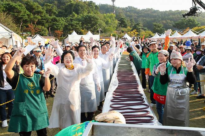 20일 이천시 농업테마공원에서 열린 쌀문화축제에서 김경희 이천시장(앞줄 왼쪽 두 번째)과 시민들이 600m 길이 가래떡을 만든 뒤 손을 흔들고 있다. 이천시 제공