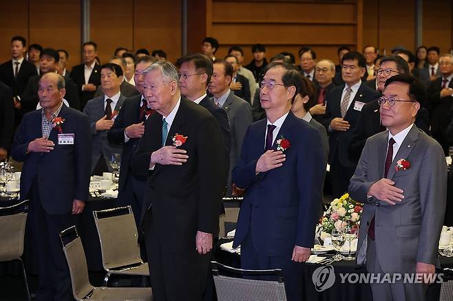 국기에 경례하는 한덕수 총리 (서울=연합뉴스) 최재구 기자 = 한덕수 국무총리가 21일 서울 중구 대한상공회의소 국제회의장에서 열린 제19대 대한노인회장 취임식에서 이중근 신임 대한노인회장 등 참석자들과 국기에 경례하고 있다. 2024.10.21 jjaeck9@yna.co.kr