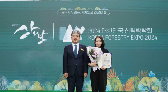 임상섭(왼쪽) 산림청장과 이수민 두나무 ESG팀 실장이 산의 날 기념식에서 기념사진을 찍고 있다. [두나무 제공]