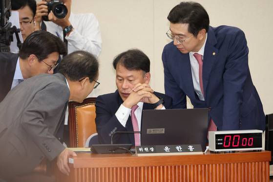 Committee chair Rep. Yoon Han-hong talks with secretaries from the People Power Party and Democratic Party at a parliamentary audit at the National Assembly on Oct. 17. [YONHAP]