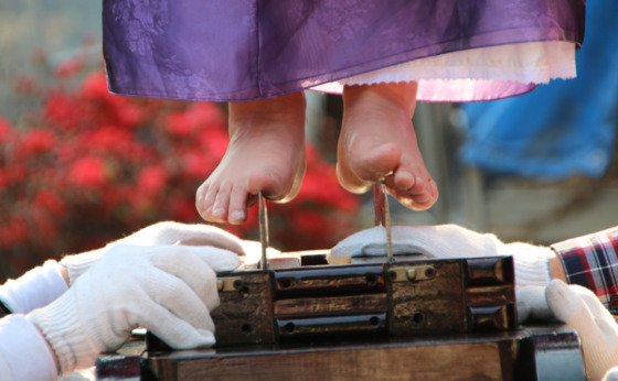 Shaman Kim Jung-hee steps onto a jakdu, or straw cutter, as part of the Jakdugeori, a segment in a gut (Korean shamanistic ritual) wherein the shaman rides knives while possessed by the Jakdu general to prevent misfortune. [KIM JUNG-HEE]