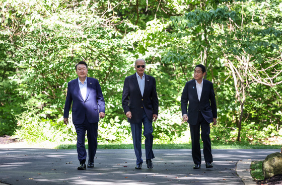 Korean President Yoon Suk Yeol, left, U.S. President Joe Biden, center, and former Japanese Prime Minister Fumio Kishida walk together toward a joint press conference at Camp David, the U.S. presidential retreat near Washington, on Aug. 18, 2023. [YONHAP]