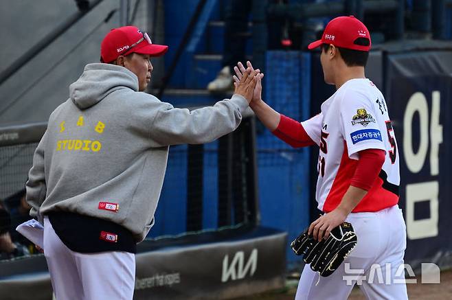 [광주=뉴시스] 이영주 기자 = 23일 광주 북구 광주-기아챔피언스필드에서 재개된 2024 KBO 포스트시즌 한국시리즈 1차전 삼성 라이온즈와 KIA 타이거즈의 경기, 6회 초 이닝을 마친 KIA 전상현이 덕아웃으로 들어서며 이범호 감독과 인사하고 있다. 2024.10.23. leeyj2578@newsis.com