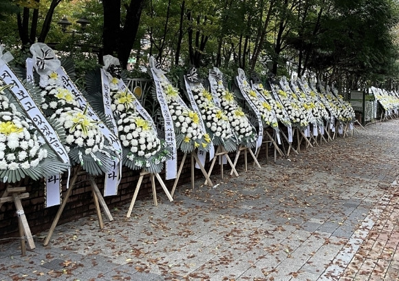 경기 성남시의의원의 자녀가 연루된 이른바 ‘모래 학폭’이 발생한 성남의 한 초등학교 인근에 지역 학부모들이 보낸 근조 화환이 설치돼 있다. 자료 : 온라인 커뮤니티