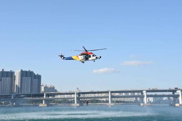 24일 오후 부산 남구 용호별빛공원 앞 해상에서 남해해경이 물에 빠진 사람을 헬기를 통해 구조하고 있다. 이날 남구는 일본에서 지진이 난 상황을 가정, 해일 피해에 대비하기 위해 합동훈련을 진행했다.  부산 남구 제공