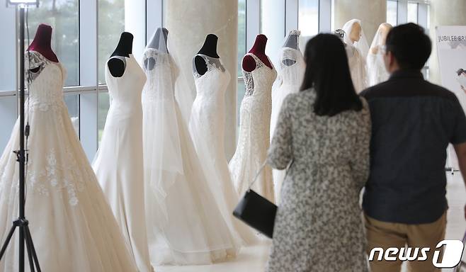 26일 오후 서울의 한 박람회를 찾은 예비 부부가 드레스 등 결혼 관련 상품을 둘러보고 있다. 2019.5.26/뉴스1 ⓒ News1 구윤성 기자