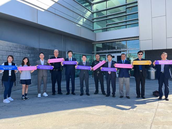 Members of the Korean American community pose for photos in front of the LAPD station in Koreatown, Los Angeles, on Oct. 22, as part of the "K-Respect" campaign event. (Sunfull Foundation)