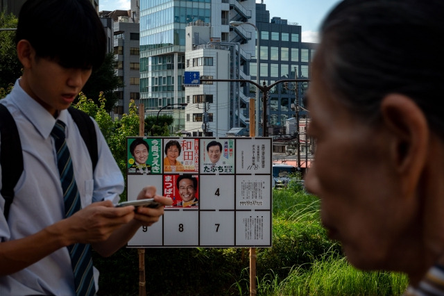 오는 27일 열리는 일본 중의원 선거를 앞둔 15일 후보 공고물 앞을 시민들이 지나가는 모습. 신화뉴시스