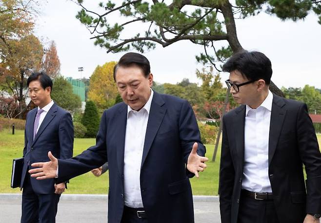 윤석열 대통령이 지난 21일 서울 용산 대통령실에서 국민의힘 한동훈 대표를 만나 차담 장소인 파인그라스로 이동하며 대화하고 있다.ⓒ 대통령실 제공