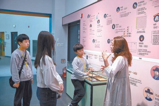 노원수학문화관 2층 '수학과 세상' 전시에서 동·서양 수학자를 보기 좋게 정리한 '한눈에 보는 수학사' 연표를 보며 강신현 해설사의 수학사 설명을 듣는 소중 학생기자단.