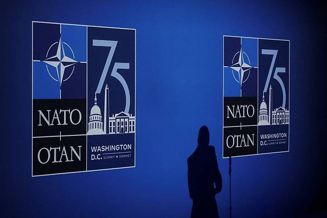 A journalist casts a shadow next to logos on the day of the NATO 75th Anniversary celebratory event in Washington, US, July 9, 2024. (File Photo - Reuters)