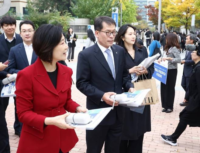 오영주 중소벤처기업부 장관과 김성태 IBK기업은행장이 구로동지점 직원들과 함께 출근길 중소기업 재직자들에게 상품안내장을 직접 전달하고 있다./사진=IBK기업은행