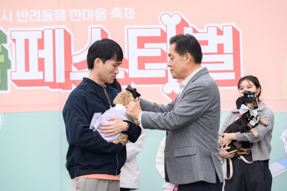 27일 이재준 수원시장이 ‘똑독(똑똑한 DOG) 페스티벌’에 참가한 매너견에게 학사모를 씌워지고 있다. (수원시 제공)