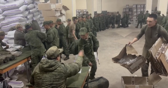 Soldiers believed to be from North Korea are standing in line to receive Russian military supplies on Oct. 19 in a screen capture of video footage released by the Ukrainian Center for Strategic Communication and Information Security, also known as Spravdi. [SCREEN CAPTURE]