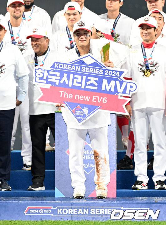 [OSEN=광주, 이대선 기자] KIA 타이거즈가 불패의 12번째 우승을 달성했다.&nbsp;KIA는 28일 광주-기아 챔피언스필드에서 열린 삼성 라이온즈와의 2024 신한은행 SOL 뱅크 KBO 한국시리즈 5차전에서 접전끝에 7-5로 승리했다.&nbsp;선발 양현종이 홈런 3개를 맞고 5실점했으나 두터운 불펜이 무실점으로 막고 추격전을 벌였다.최형우의 홈런포함 2타점, 김태군의 역전타와 박찬호의 귀중한 쐐기타가 나왔다. 시리즈&nbsp;4승1패로 우승의 감격을 누렸다.&nbsp;한국시리즈 MVP를 수상한 KIA 김선빈이 기념촬영을 하고 있다. 2024.10.28 / sunday@osen.co.kr