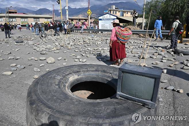 차량통행 어려워진 볼리비아 도로 (코라 AFP=연합뉴스) 28일(현지시간) 볼리비아 수도 라파스와 코차밤바를 잇는 코라 지역 도로에 돌과 타이어가 잔뜩 놓여 있다. 2024.10.29