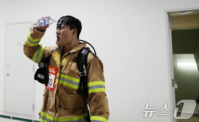 30일 부산 해운대구 엘시티에서 열린 전국소방고무원 엘시티 계단오르기 대회에서 참가자가 물로 더위를 식히고 있다. 2024.10.30/뉴스1 ⓒ News1 윤일지 기자