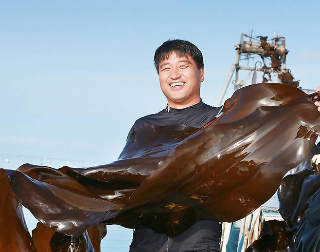 청정 바다인 전남 완도군 신지면 해역에서 건져 올린 싱싱한 다시마를 어민이 들어 보였다. 다시마는 전복의 먹이이자 다양한 가공식품으로 개발되고 있다. 대한물산 제공