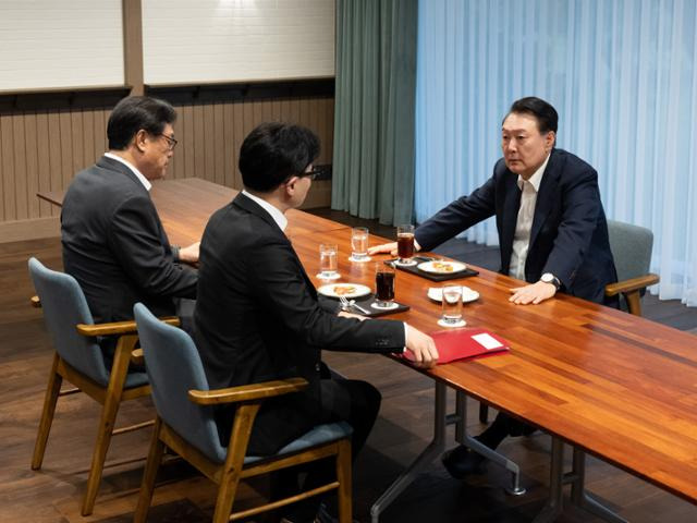 윤석열 대통령이 21일 서울 용산 대통령실에서 한동훈 국민의힘 대표와 만나 대화를 나누고 있다. 윤 대통령의 강렬한 표정과 기다란 테이블을 사이에 두고 마주 앉은 두 사람의 자리 배치가 인상적이다. 한 대표 옆은 배석한 정진석 대통령비서실장. 대통령실 제공