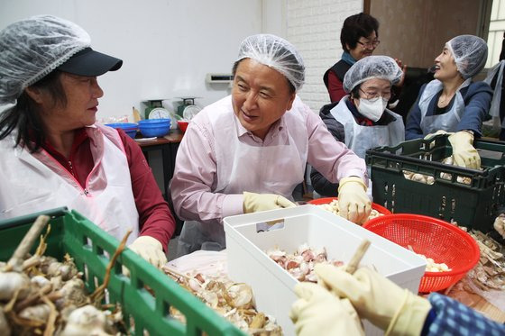 김영환 충북지사가 지난 21일 충북 청주 두꺼비시장을 찾아 일하는 밥퍼 참여자와 마늘 꼭지 따기 작업을 하고 있다. 사진 충북도