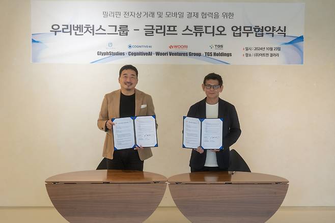 TGS Holding Chairman Lee Jae-sun (left) poses for a photo with Glyphstudios CEO Gerry Amisola at the memorandum of understanding signing ceremony held at the Artpin Gallery in Seoul on Oct. 23. (TGS Holdings)