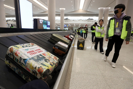 "Passengers" search for their luggage during a test operation at the Incheon International Airport’s Terminal 2 on Wednesday. [YONHAP]