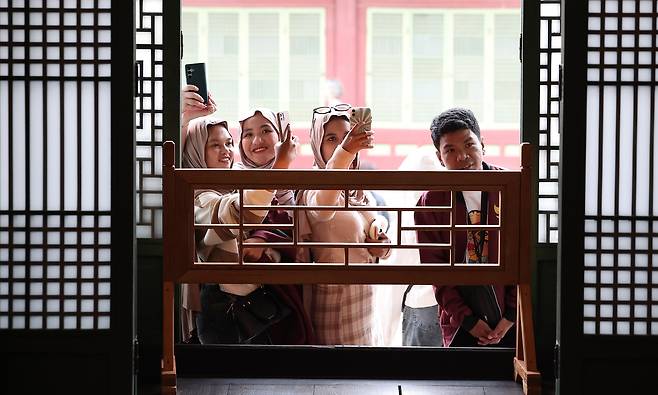 Foreign tourists take pictures of the inside of Changdeok Palace's Huijeongdang Hall in central Seoul on Oct. 1. [NEWS1]