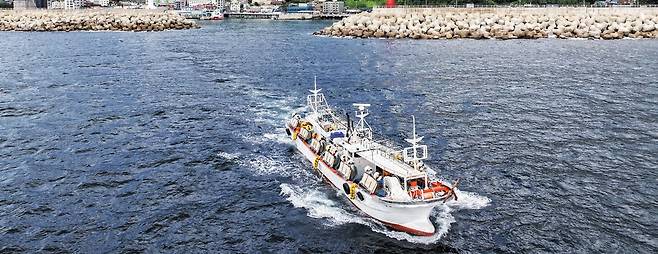 경북 울릉군 저동항에서 오징어잡이 배 한 척이 출항하고 있다. 9~10월 오징어 철이 되면 어선 120여 척이 불을 밝히고 오징어를 낚았는데 요즘은 어획량이 크게 줄어 하루 8~9척만 바다로 나간다. /울릉군