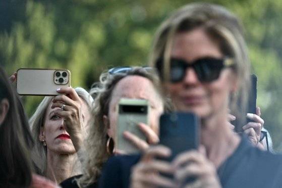 2024년 9월 12일 워싱턴 DC 백악관 남쪽 잔디밭에서 조 바이든 미국 대통령이 여성폭력방지법 제정 30주년을 앞두고 연설하기 전에 참석자들이 휴대전화로 사진을 찍고 있다. AFP=연합뉴스