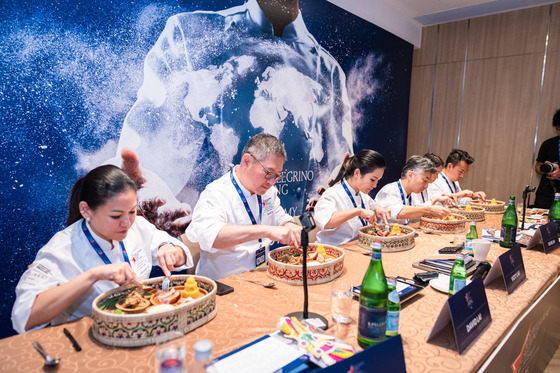 The panel of judges at S. Pellegrino Young Chef Academy Competition's Asia regionals try the contestants' dishes at the International Culinary Institute in Hong Kong on Monday. [S.PELLEGRINO YOUNG CHEF ACADEMY]