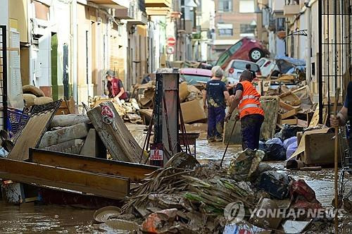 스페인 발렌시아 지역의 주민들이 진흙으로 뒤덮인 가재도구를 정리하고 있다.  [AFP 연합뉴스 자료사진. 재판매 및 DB 금지]