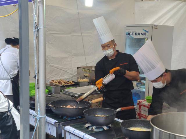 1일 구미라면축제에서 독일식 짜장라면을 조리 중인 라면 셰프가 다진 고기를 빠르게 익히려고 대형 토치를 사용하는 모습. 구미=박경담 기자