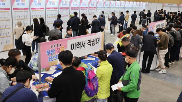 지난달 24일 부산 해운대구 벡스코 제1전시장에서 열린 '2024 부산 잡(JOB) 페스티벌'에서 구직자들이 이력서를 작성하는고 있다. 연합뉴스