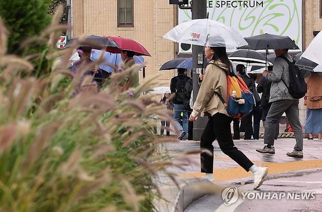 가을비 내리는 출근길 (서울=연합뉴스) 서대연 기자 = 비가 내린 22일 오전 서울 종로구 광화문네거리에서 시민들이 우산을 쓰고 신호를 기다리고 있다. 2024.10.22 dwise@yna.co.kr