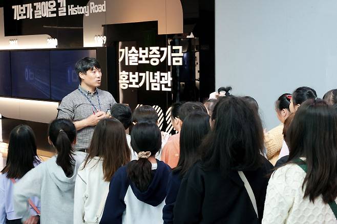 4일 부산광역시 남구의 기술보증기금 팝업 과학관 체험행사에 참여한 학생들이 기보 관계자의 설명을 듣고 있다(사진=기술보증기금)