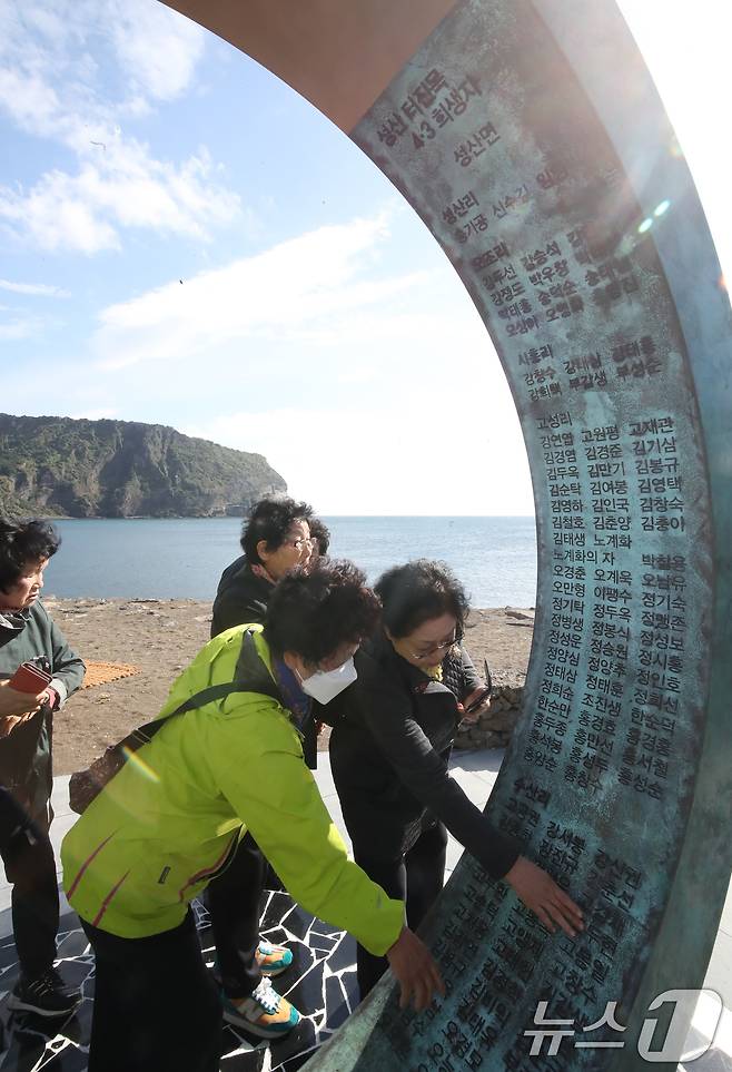 5일 오전 제주 서귀포시 성산읍 고성리 터진목해안가 4·3추모공원에서 유족들이 이날 제막한 조형물 '해원의 문'에서 제주4·3 당시 희생된 가족의 이름을 찾고 있다. 2024.11.5/뉴스1 ⓒ News1 오현지 기자