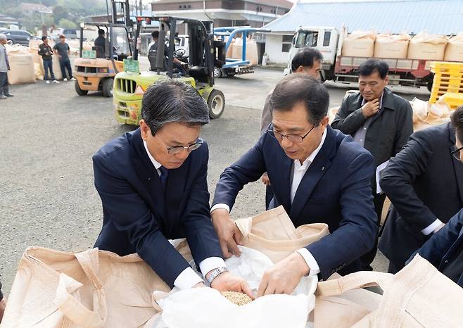 김돈곤 충남 청양군수(왼쪽)가 4일 공공비축미곡 매입 현장에서 올해 수확한 벼 품질을 살피고 있다. 청양군 제공