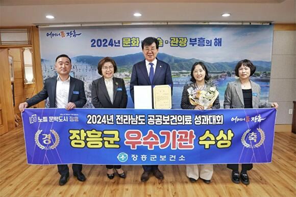 전라남도 장흥군 관계자들이 2024년 전라남도 공공보건의료 성과대회 우수기관 수상 관련 현수막을 들고 있다. [사진=장흥군]