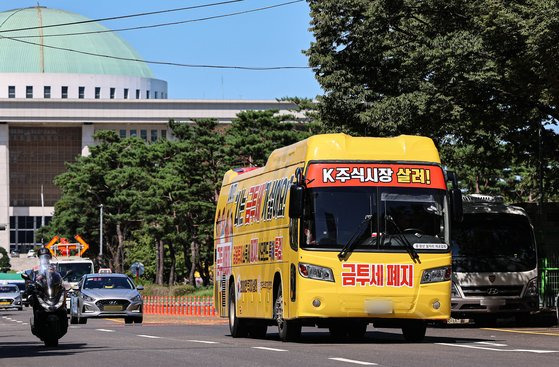 한국주식투자자연합회가 제작한 금융투자소득세 폐지 촉구 집회버스가 지난 9월 서울 영등포구 국회의사당 인근에서 운행되고 있다. 뉴스1