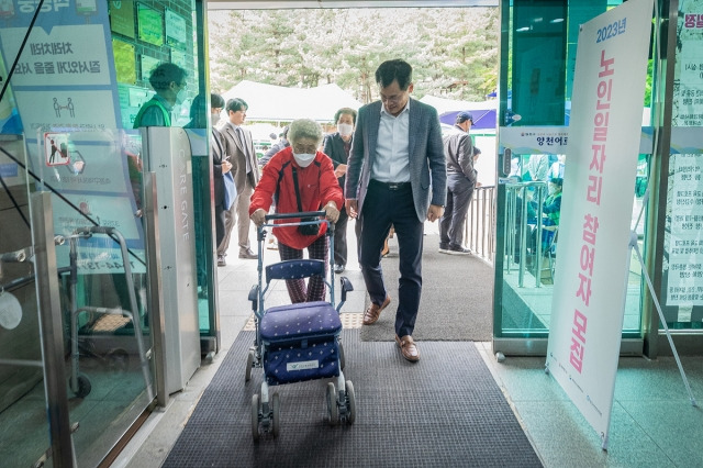 이기재 양천구청장이 보행기를 이용하는 노인과 복지관에 입장하고 있다. 양천구 제공