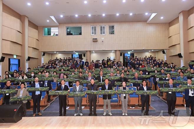 참석자들이 '힐링 봉화' 플래카드를 들고 '치유산업 국제세미나' 기념사진을 찍고 있다(봉화군 제공)2024.11.6/뉴스1