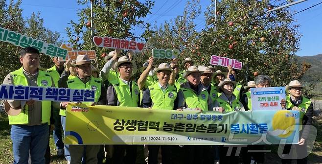 대구도시개발공사와 광주도시공사 임직원들이 6일 대구 군위군 부계면에서 달빛동맹 농촌일손돕기 봉사 활동을 펼친 뒤 기념사진을 찍고 있다.(대구도시개발공사 제공)